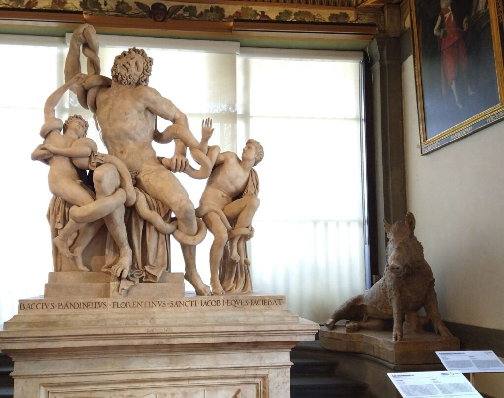 Nella immagine si vede la statua romana originale in marmo del porcellino. Siamo al termine del corridoio di ponente della galleria degli Uffizi. Insieme al porcellino, nella foto, si vede una copia del Laocoonte eseguita da Baccio Bandinelli  