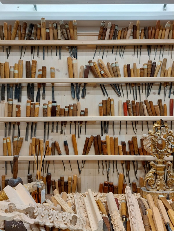 nell'immagine si vedono gli strumenti da lavoro per l'intaglio del legno e alcuni pezzi lavorati nella bottega d'arte maselli in via dei ginori a firenze